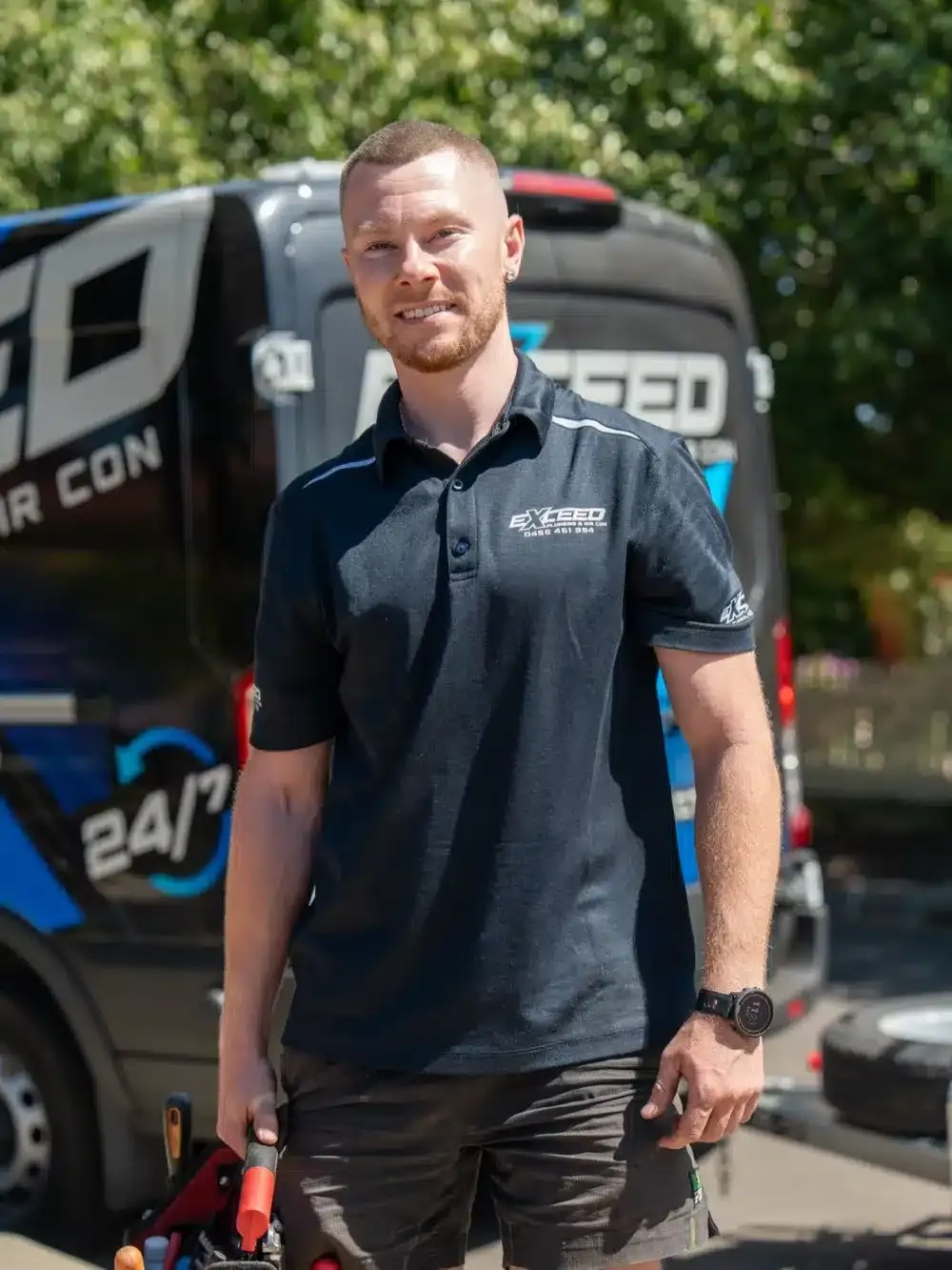 Caleb John, owner of Exceed Plumbing, beside the service van